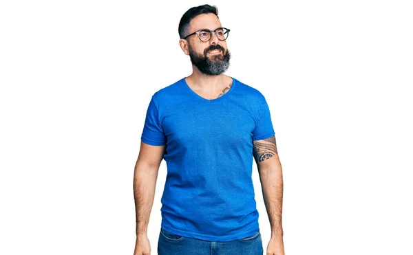 一个留着胡子的西班牙裔男人 穿着休闲装 戴着眼镜 面带微笑地望着别处 表情自然 充满自信地大笑 — 图库照片
