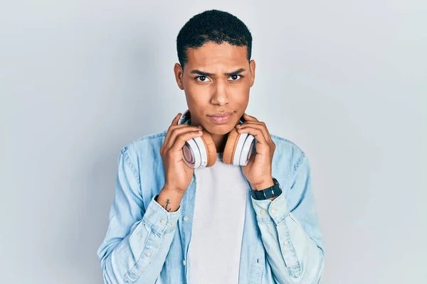 Joven Afroamericano Tipo Escuchando Música Usando Auriculares Escéptico Nervioso Frunciendo —  Fotos de Stock