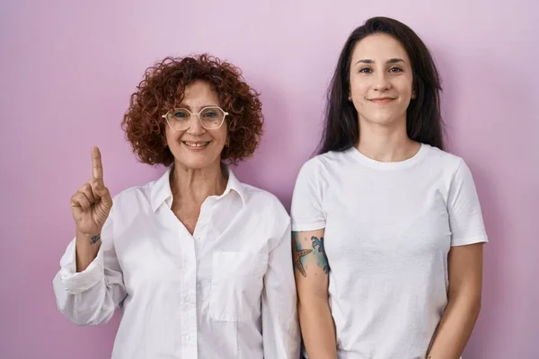 Hispanic Mother Daughter Wearing Casual White Shirt Pink Background Showing — Stock Photo, Image