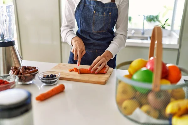 年轻的金发女人在厨房切胡萝卜 — 图库照片