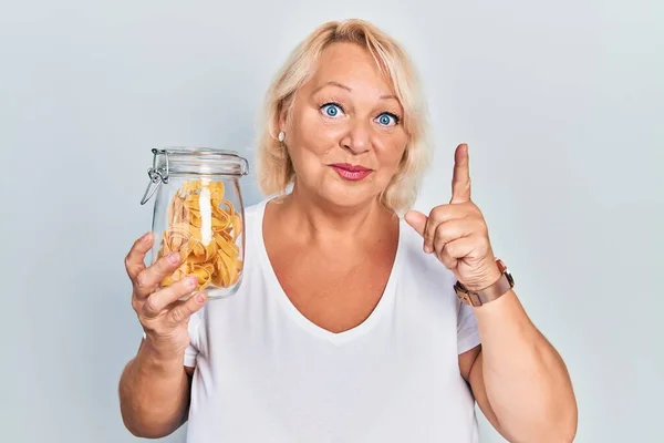 Middle Age Blonde Woman Holding Uncooked Noodles Smiling Idea Question — Stock Photo, Image