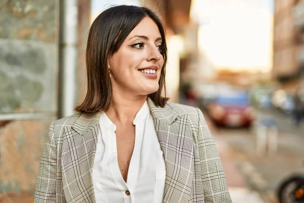 Genç İspanyol iş kadını şehirde mutlu mesut ayakta duruyor..