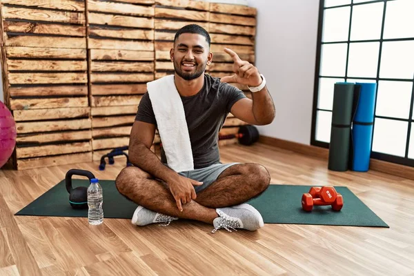 Young Indian Man Sitting Training Mat Gym Smiling Confident Gesturing — Stok fotoğraf