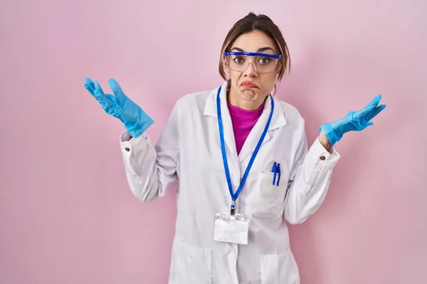 Donna Ispanica Con Uniforme Scienziato Espressione Indiscussa Confusa Con Braccia — Foto Stock