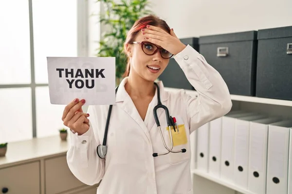 Young Caucasian Woman Wearing Doctor Uniform Holding Thank You Banner — Foto Stock