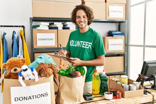 Yardım derneğindeki panoya mutlu yazılar yazarak gülümseyen genç İspanyol gönüllü adam..