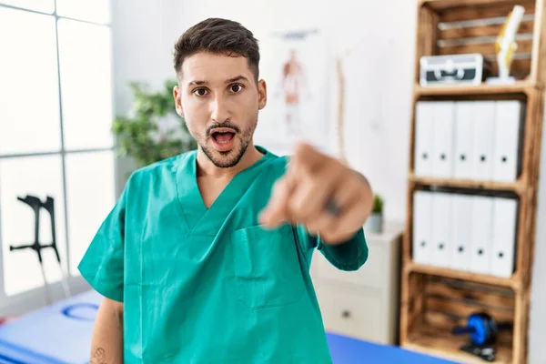 Young Physiotherapist Man Working Pain Recovery Clinic Pointing Displeased Frustrated —  Fotos de Stock