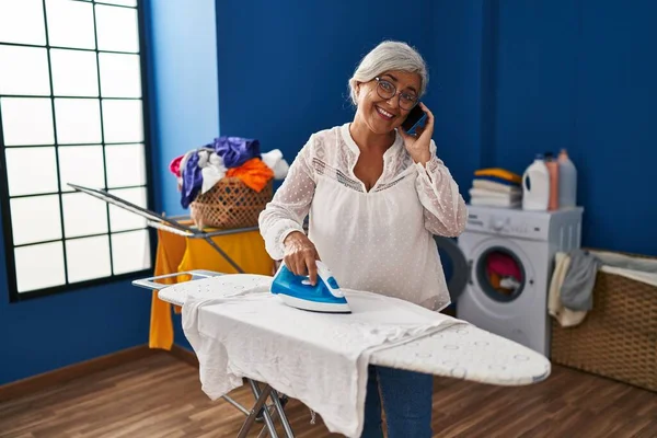 Middle Age Woman Talking Smartphone Ironing Clothes Laundry Room — Stock Photo, Image