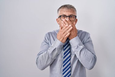 Gri saçlı, gözlüklü İspanyol bir iş adamı ağzını yanlışlıkla elleriyle kapatmış. gizli kavram. 