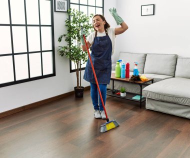 Orta yaşlı İspanyol kadın evde hizmetçi olarak dans ediyor.