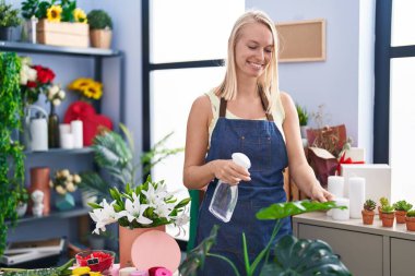 Çiçekçide kendine güvenen genç sarışın bir çiçekçi.