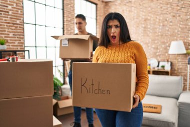 Genç bir çift yeni bir eve taşınıyor. Şok olmuş yüzlü karton kutularla. Şüpheci ve alaycı görünüyorlar. 