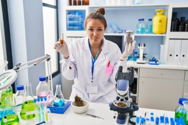 Laboratuvarda esrar çeken genç İspanyol kadın depresyonda ve endişe içinde, kızgın ve korkmuş bir şekilde ağlıyor. hüzünlü ifade. 