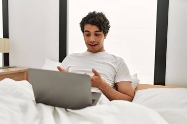 Genç İspanyol adamın yatak odasında dizüstü bilgisayarla görüntülü konuşması var..