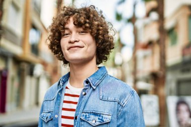 Genç İspanyol adam şehre gülümsüyor.