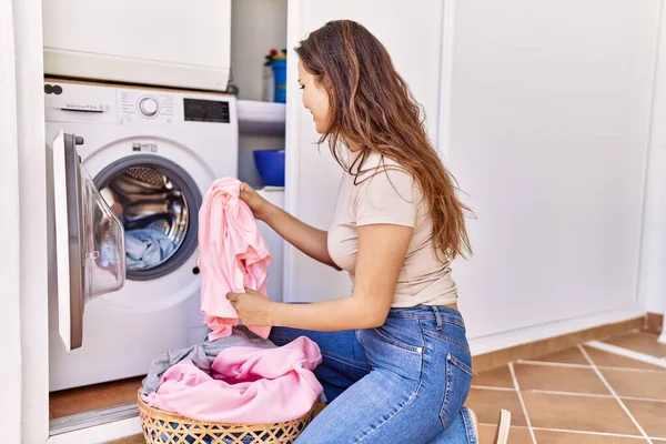 他那个惊慌的小女孩正在洗衣服 把衣服放在家里的洗衣机里 — 图库照片
