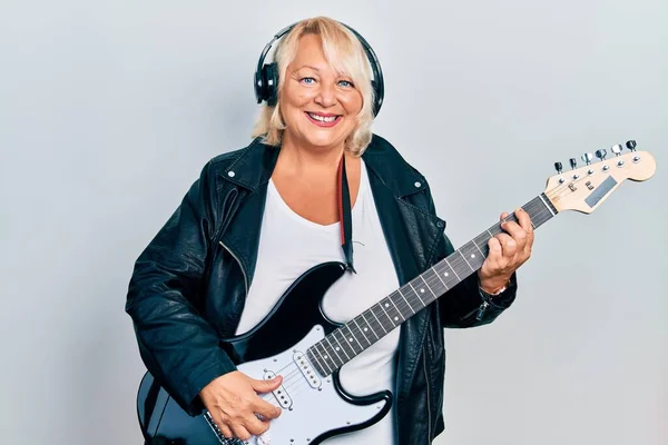 Middle Age Blonde Woman Playing Electric Guitar Using Headphones Smiling — Fotografia de Stock
