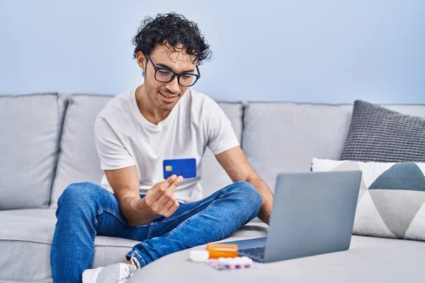 Молодий Іспаномовний Чоловік Використовує Ноутбук Кредитну Картку Сидячи Дивані Вдома — стокове фото