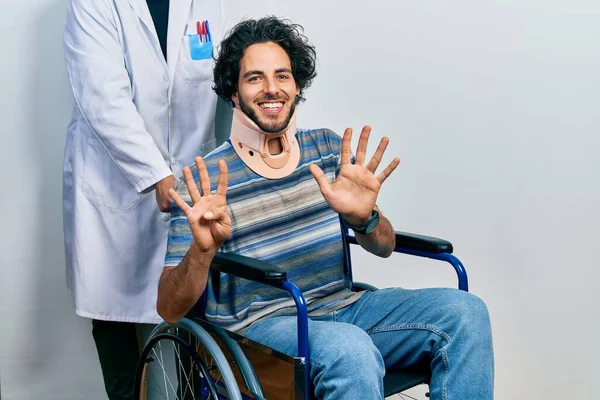 英俊的惊慌失措的男人坐在轮椅上 脖子上戴着项圈 用9号手指指尖 面带微笑 自信而快乐 — 图库照片