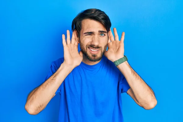 Jovem Hispânico Vestindo Roupas Casuais Tentando Ouvir Ambas Mãos Gesto — Fotografia de Stock