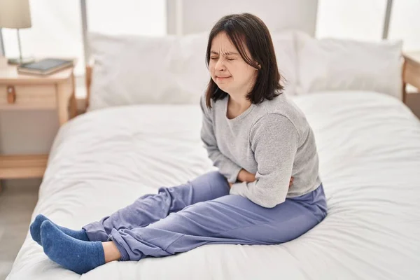 Mladá Žena Downovým Syndromem Trpí Menstruační Bolesti Sedí Posteli Ložnici — Stock fotografie