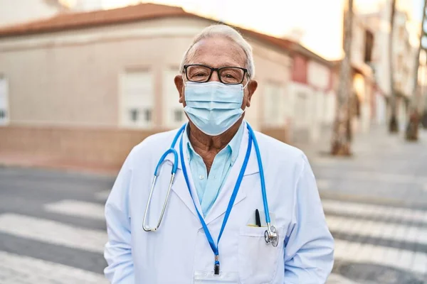 Senior man wearing doctor uniform wearing medical mask at street