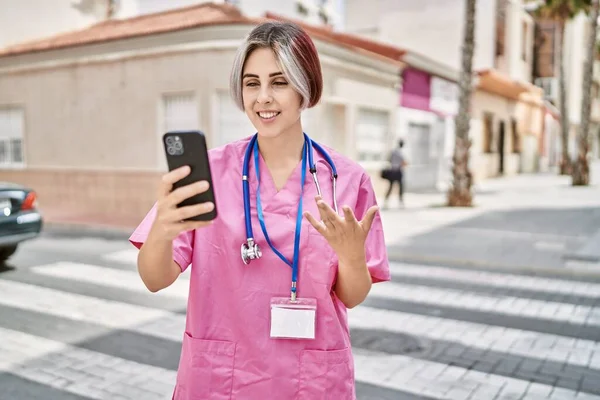 在城市里 年轻的高加索女医生正在用智能手机进行视频通话 — 图库照片