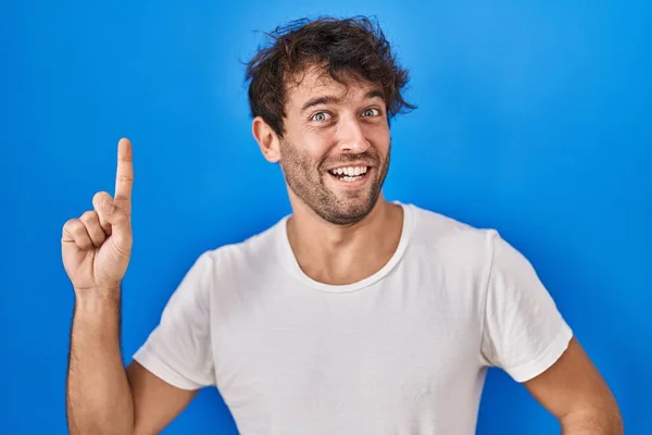 Hispanic Ung Man Står Över Blå Bakgrund Pekar Finger Upp — Stockfoto