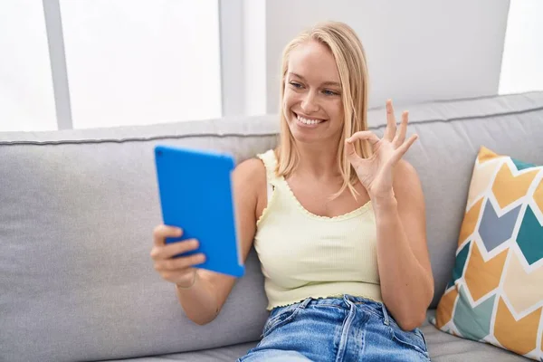 Mujer Caucásica Joven Usando Touchpad Sentado Sofá Haciendo Signo Con —  Fotos de Stock