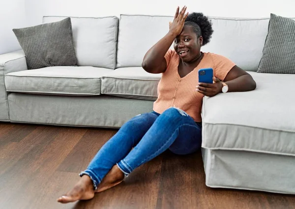 Giovane Donna Africana Utilizzando Smartphone Seduto Sul Pavimento Casa Sorpreso — Foto Stock