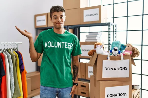 Bağışlarda Gönüllü Tişört Giyen Genç Yakışıklı Spanyol Adam Gülümseyen Elinde — Stok fotoğraf