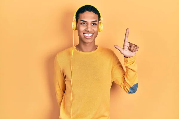 Giovane Ragazzo Afroamericano Che Ascolta Musica Usando Cuffie Mostrando Indicando — Foto Stock