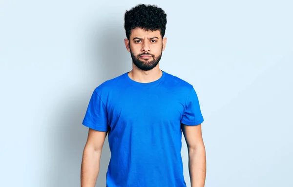 年轻的阿拉伯男子留着胡子 穿着休闲的蓝色T恤 忧心忡忡 哭哭啼啼 悲伤的表情 — 图库照片