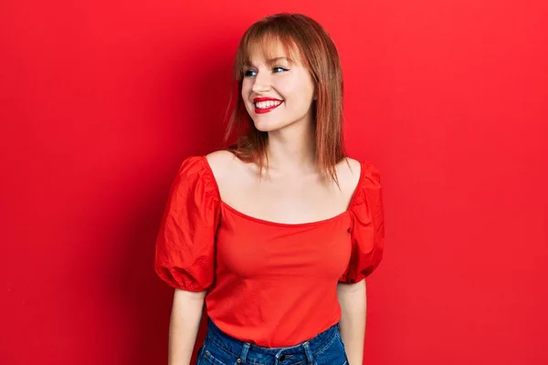 Kırmızı Tişörtlü Kızıl Saçlı Genç Bir Kadın Yüzünde Gülümsemeyle Yan — Stok fotoğraf
