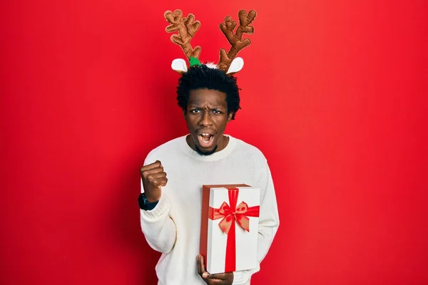 Молодой Африканский Американец Рождественской Шляпе Держит Руках Подарок Злой Безумный — стоковое фото