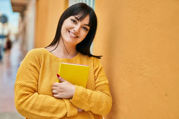 Junge Brünette Frau Lächelt Glücklich Mit Buch Der Wand Gelehnt — Stockfoto