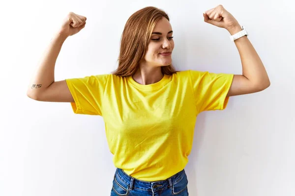 Jonge Brunette Vrouw Staat Geïsoleerde Achtergrond Tonen Armen Spieren Glimlachen — Stockfoto