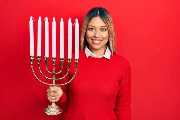 Beautiful Hispanic Woman Holding Menorah Hanukkah Jewish Candle Looking Positive — Stock Photo, Image