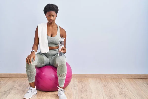 Afrikansk Amerikansk Kvinna Sportkläder Sitter Pilates Boll Skeptisk Och Nervös — Stockfoto