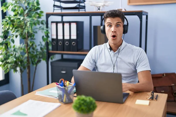 Young Hispanic Man Working Office Wearing Headphones Afraid Shocked Surprise — Stockfoto