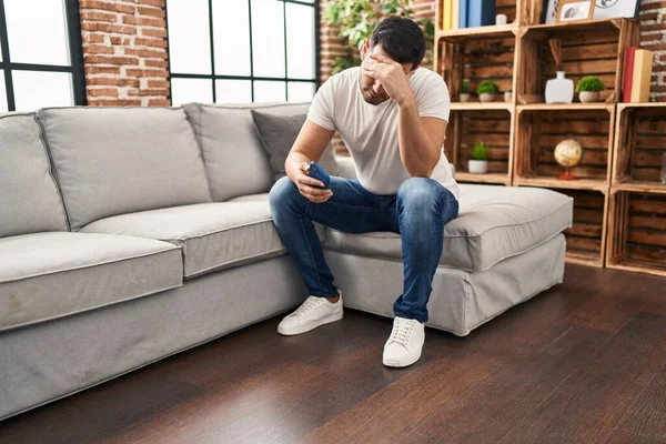 Hombre Hispano Joven Usando Teléfono Inteligente Sentado Sofá Casa — Foto de Stock