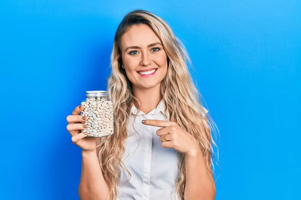 Beautiful Young Blonde Woman Holding Bottle Raw White Beans Smiling — Stock Fotó