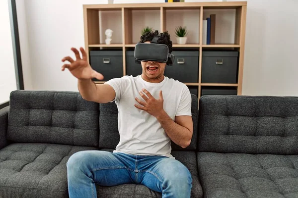 Jovem Hispânico Assustado Brincando Com Óculos Realidade Virtual Sentado Sofá — Fotografia de Stock