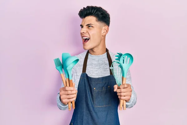 Young Hispanic Man Wearing Professional Baker Apron Holding Cooking Tools — Fotografia de Stock