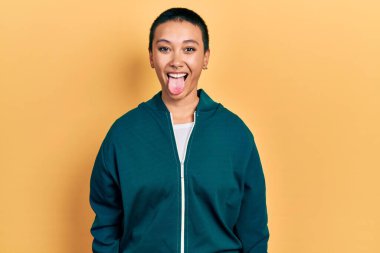 Kısa saçlı, spor ceket giyen güzel İspanyol kadın komik bir ifadeyle dilini dışarı çıkartıyor. duygu kavramı. 