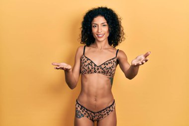 Genç Latin kız bikini giyiyor, gülümsüyor, yardım eli uzatıyor ve kabul ediyor.. 