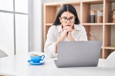 Young hispanic woman stressed teleworking at home