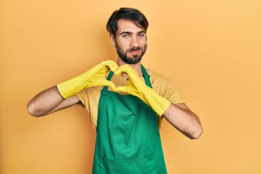 Temiz önlük ve eldivenler giyen genç bir İspanyol aşık gülümsüyor ve elleriyle kalp sembolü yapıyor. romantik kavram. 