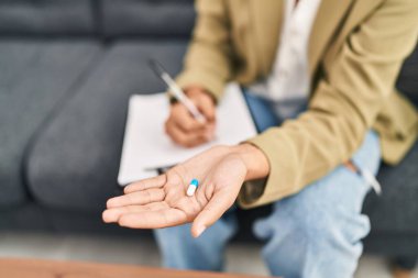 Young hispanic woman psychologist prescribe pill treatment at psychology center