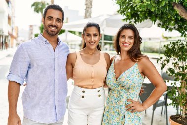 Üç İspanyol arkadaş şehirde mutlu bir şekilde gülüyor ve sarılıyorlar..